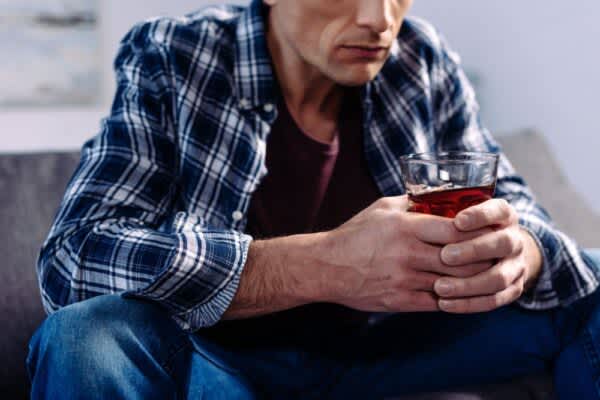 stock photo of a man holding a glass of alcohol