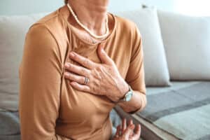 Woman experiencing chest pain clutches her chest