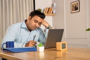 stock photo of a young man dozing off while working