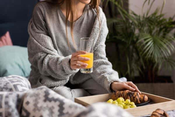 young woman makes common bedtime food mistakes while eating in bed