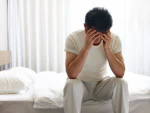 stock photo of an unhappy man lying in bed