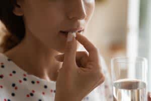 stock photo of a woman taking a pill