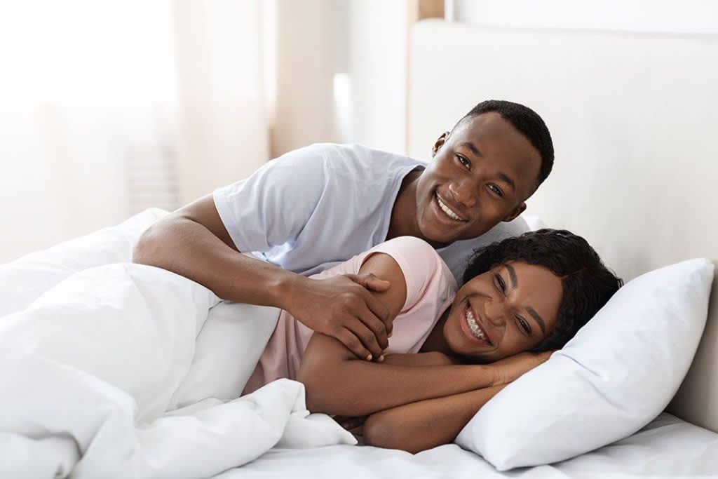 Happy couple relaxing in bed at home