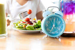 Woman eating within a specific timeframe in order to intermittent fast.