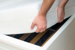 stock photo of a man lifting a mattress