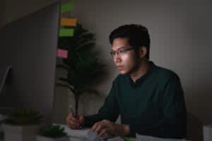 stock photo of a man at his computer late at night