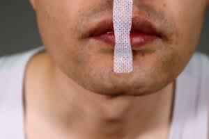 Person wearing tape for nasal breathing