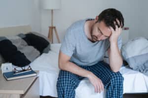 A man holds his head in his hand after a restless night