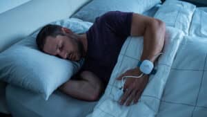 Person using a home sleep test in bed