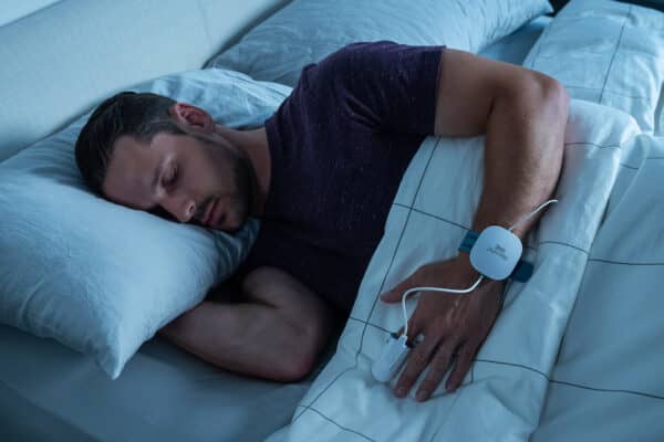 Person using a home sleep test in bed