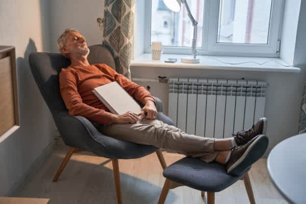 stock photo of a man taking a nap with a book in his lap