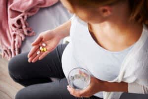 product image of a pregnany woman taking medicine