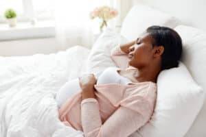 A pregnant woman resting with her hand on her stomach