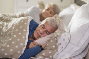 Senior couple sleeping peacefully in bed.