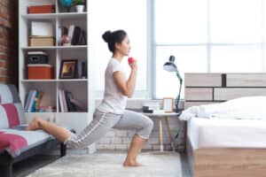 A woman does light exercise in her bedroom