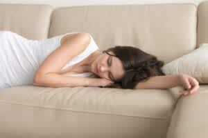 stock image of a woman sleeping on a couch without a pillow