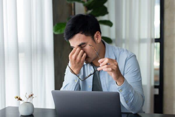 stock photo of a tired man rubbing his eyes