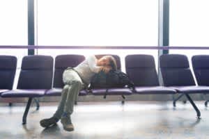 Woman with jet lag trying to sleep at airport