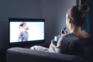 stock image of a woman watching tv at night