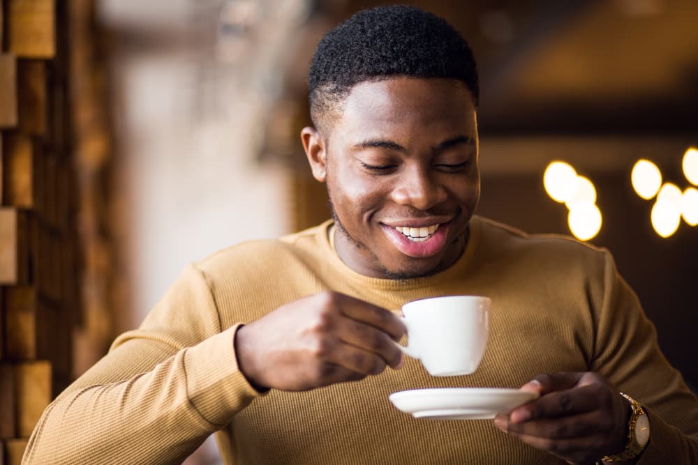 Man lifting a cup of coffee to drink