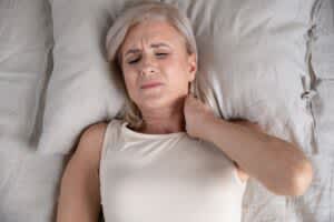 stock photo of an older woman experiencing neck pain