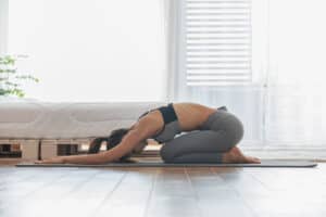 woman practicing yoga in her bedroom